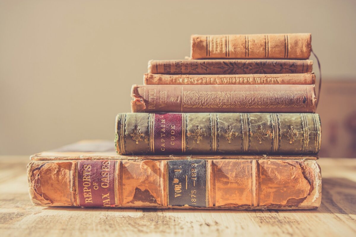 shallow focus photography of stack of books -of e-reader